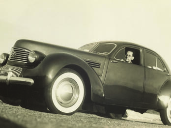 Low angle photograph of a man inside a car. 