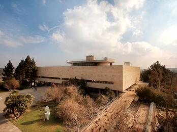 Aerial photograph of a rectangular building with a courtyard and trees.