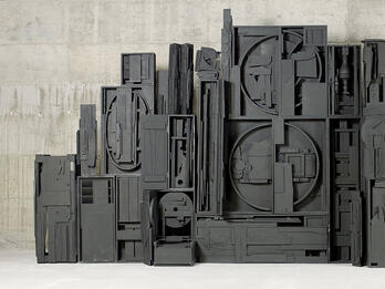Wooden monument of vertical rectangles and circles.