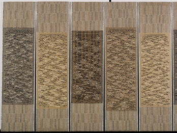 Six vertical tapestries woven in patterns in similar shades.
