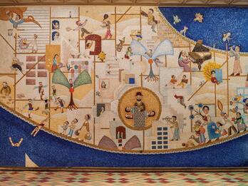 Mosaic wall depicting a city featuring different sets of stylized human figures playing sports and music, working, and caring for their families.