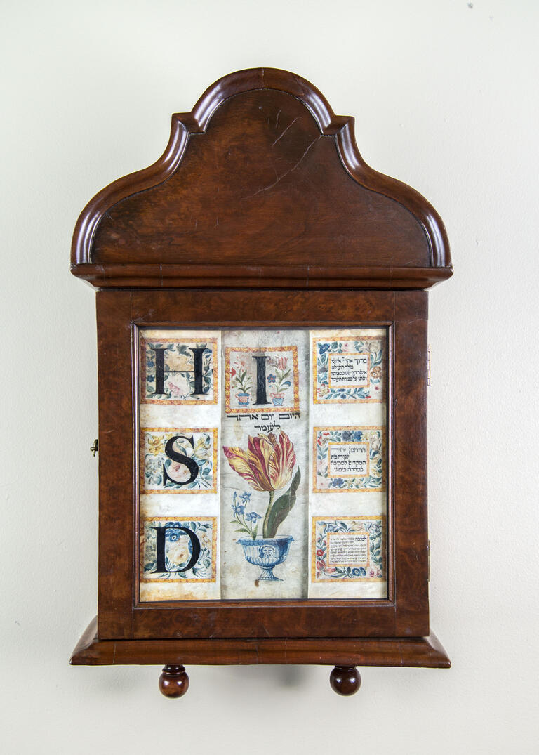 Wood wall piece with bold Hebrew letters and flowers