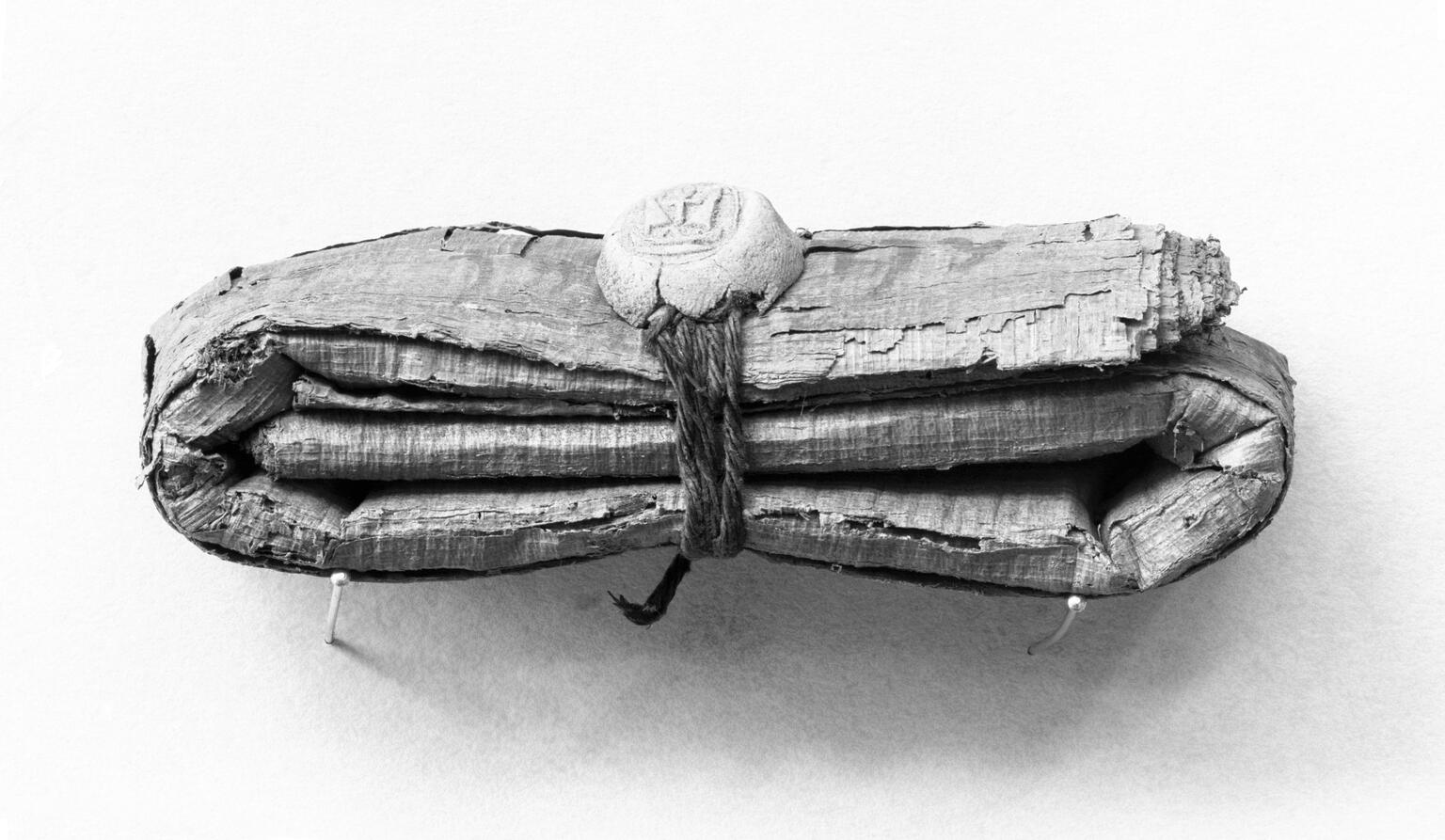 Bundle of folded papyrus tied with string and seal.