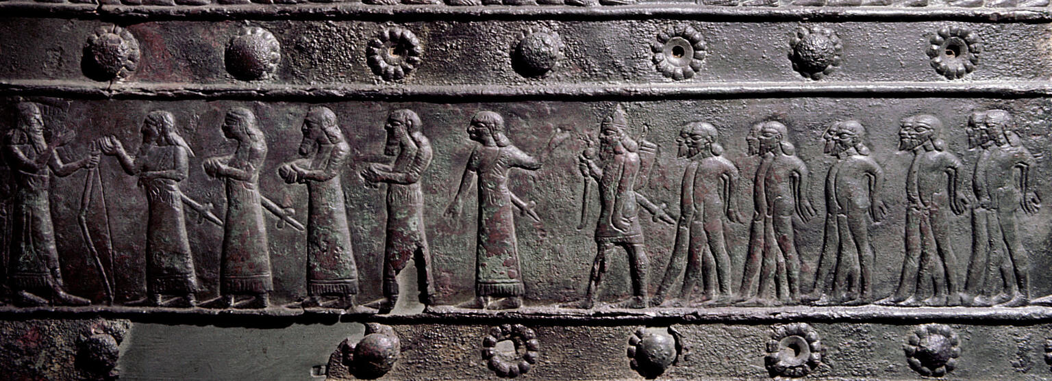 Relief of many figures in a row, some of whom are naked with hands tied behind their backs.