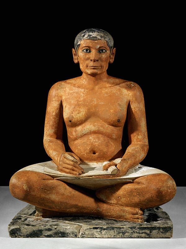 Sculpture of man sitting cross legged with scroll in his lap. Sculpture of man sitting cross legged with scroll in his lap.