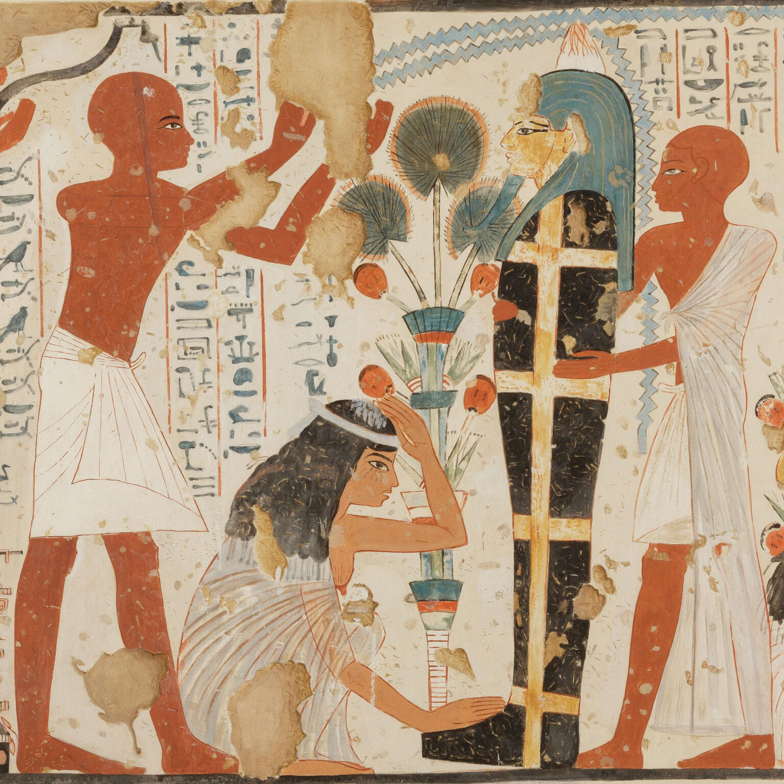 Mural of crouching woman with hand on her head next to upright mummy held up by figure in tunic, as another figure in tunic raises arms above woman, with hieroglyphic text in background. 