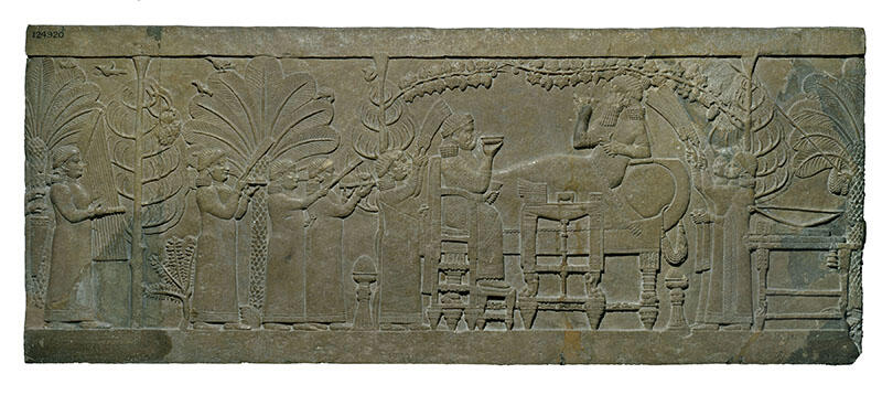 Relief of figure on chair and figure reclining on sofa, surrounded by foliage, as several smaller figures wave fans, carry platters, and play instruments.