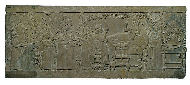 Relief of figure on chair and figure reclining on sofa, surrounded by foliage, as several smaller figures wave fans, carry platters, and play instruments. 