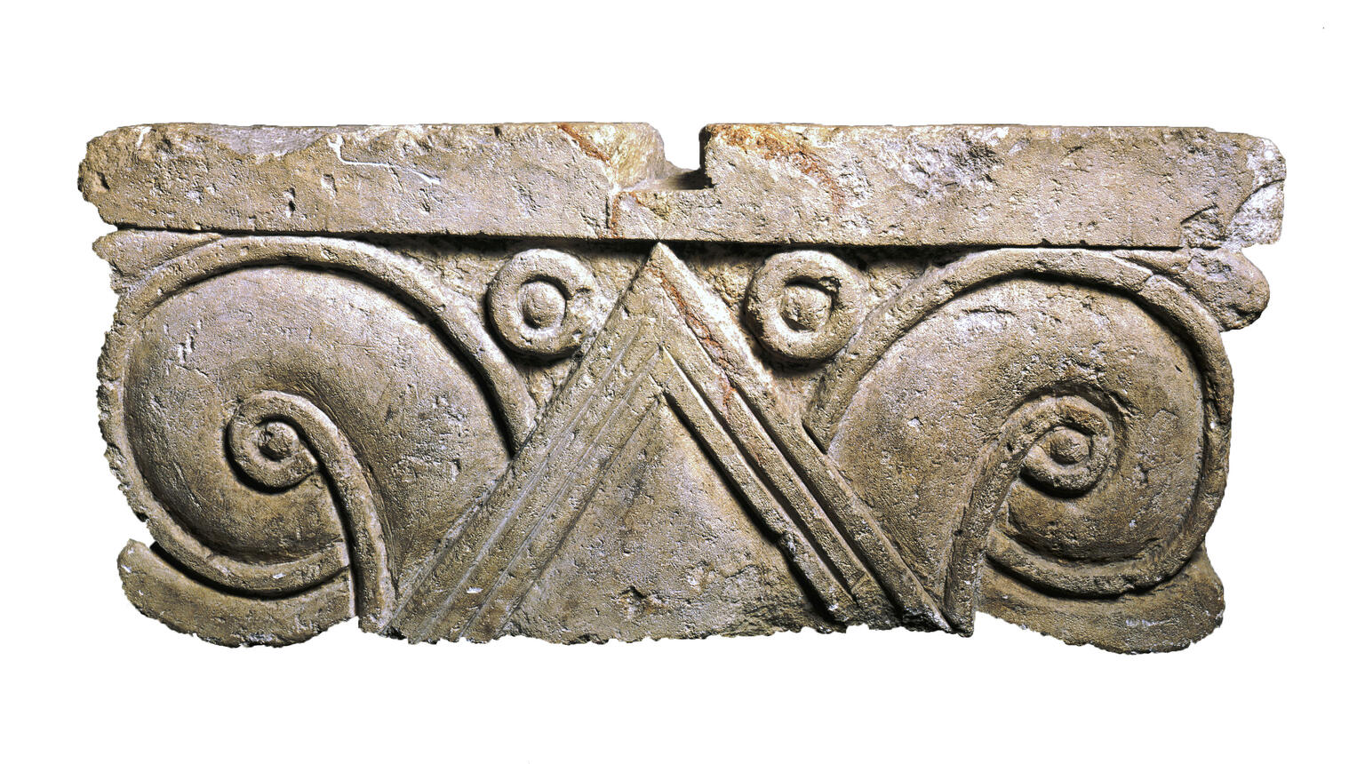 Limestone capital with triangles and carved palmette design.