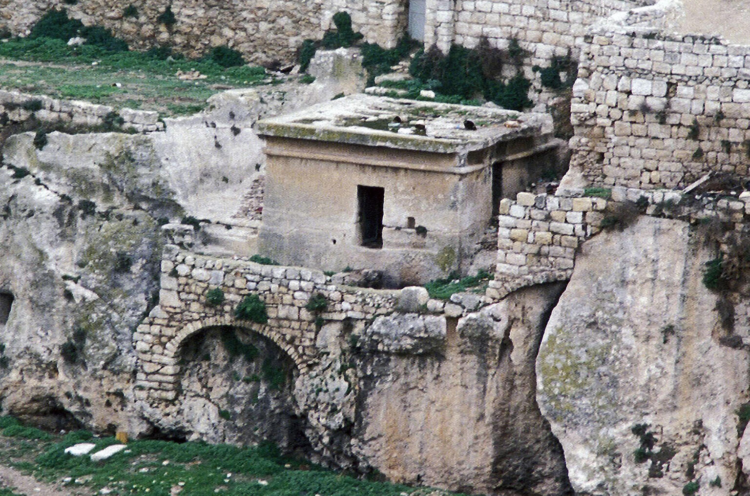 Photograph of tomb on top of stone structures.