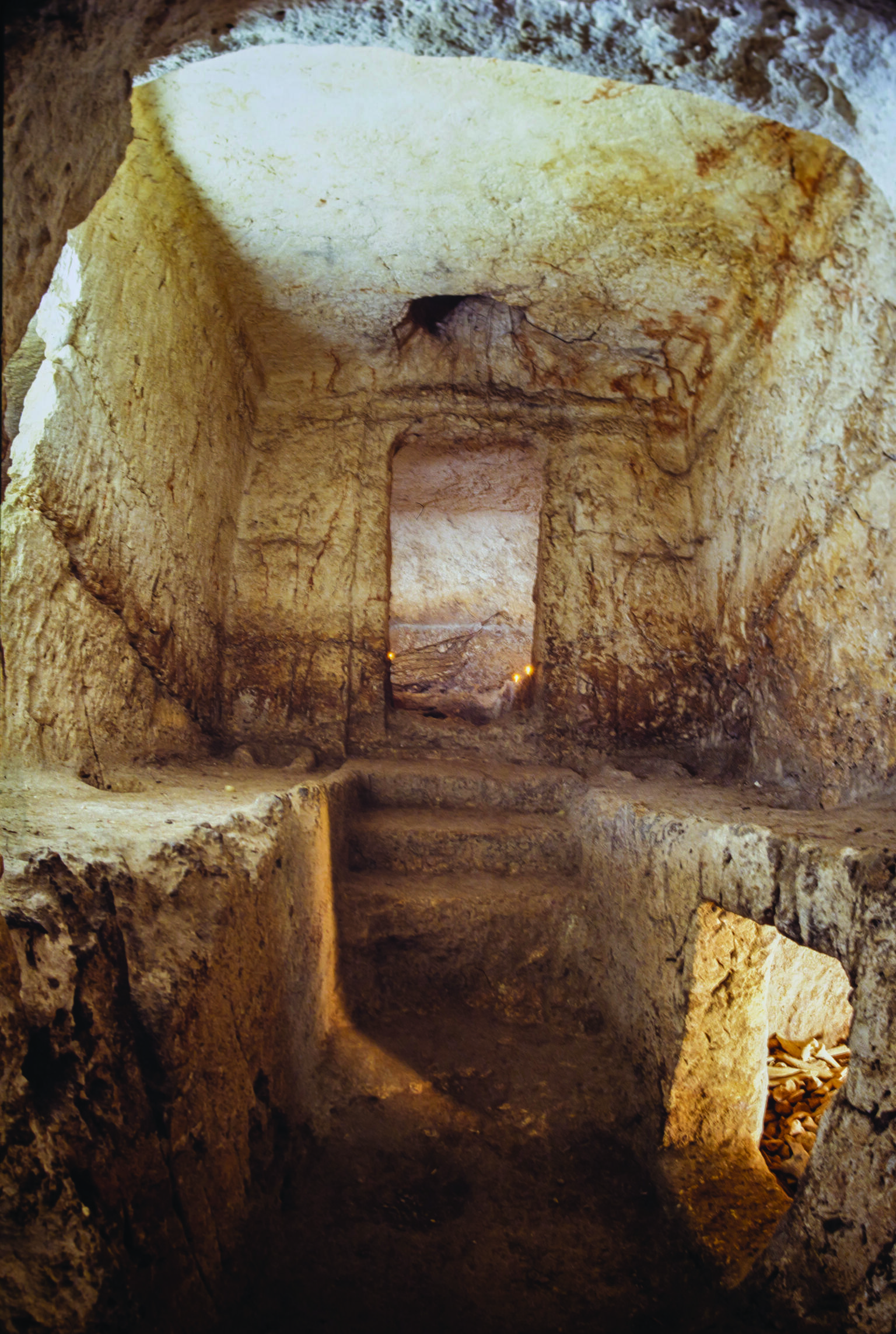 Rectangular chamber in ground with steps and several doorways. 