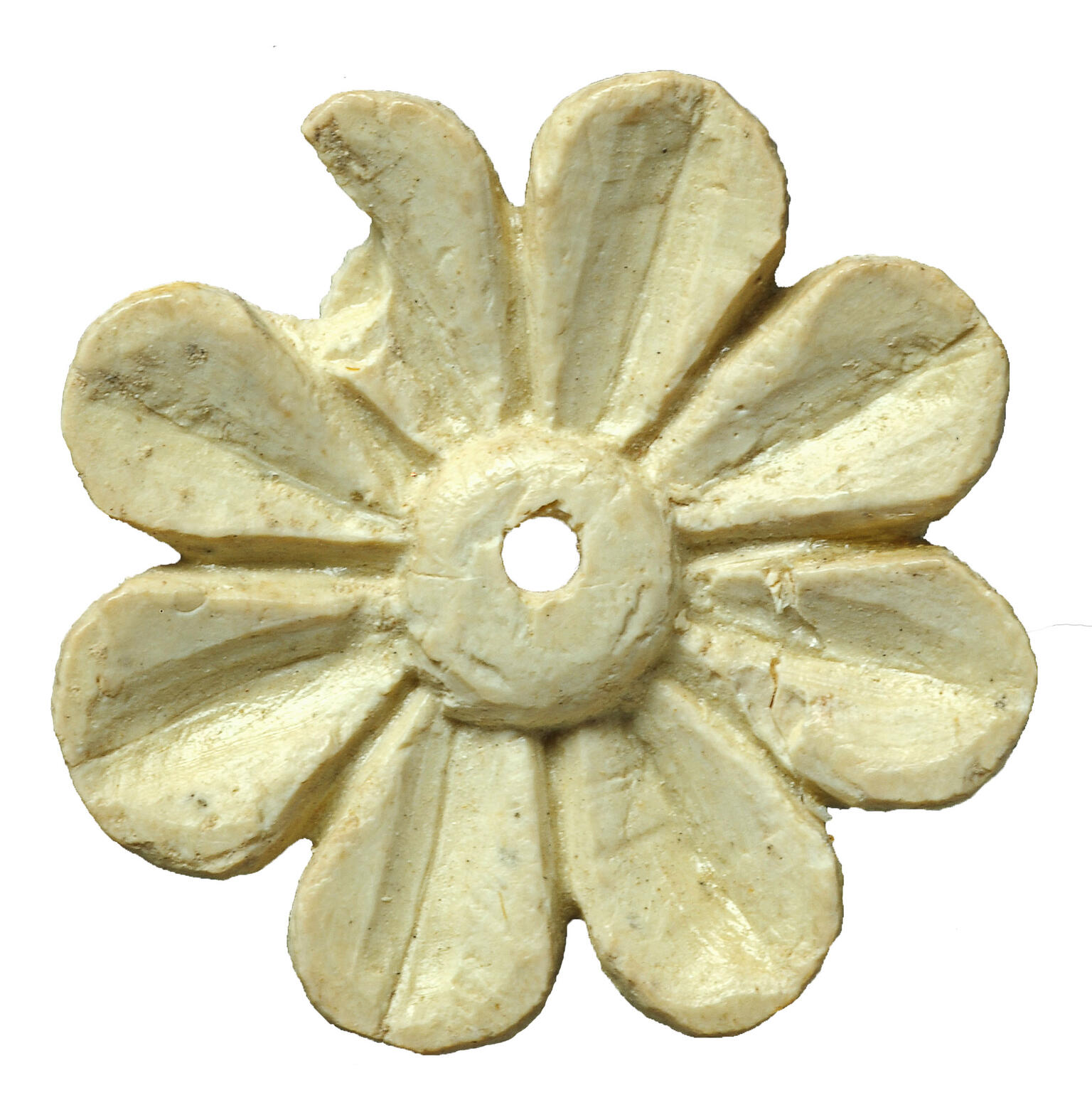 Ivory carving in shape of an eight-petaled flower with small hole in center.