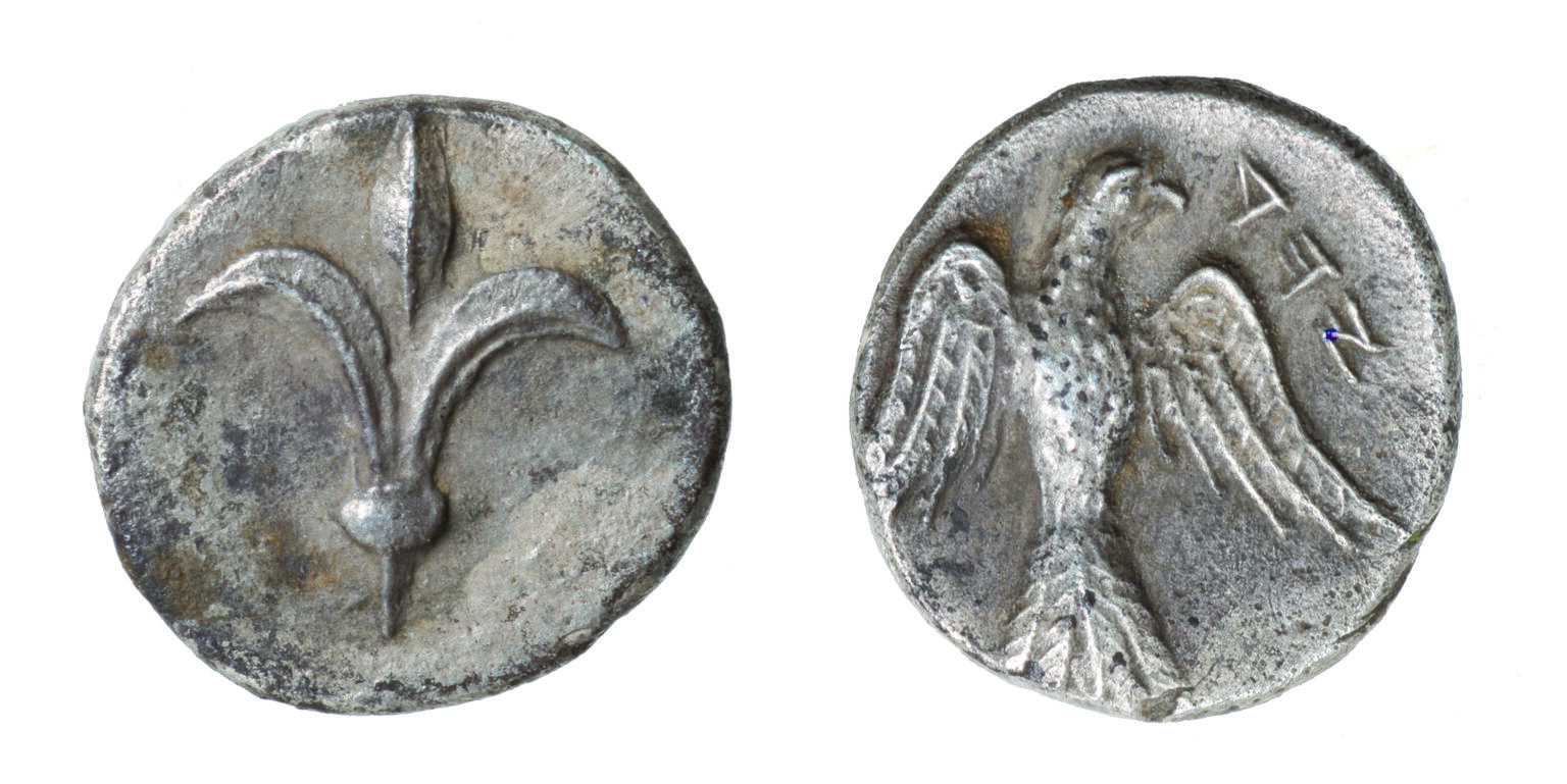 Front and back of coin, with lily on one side and falcon on the other