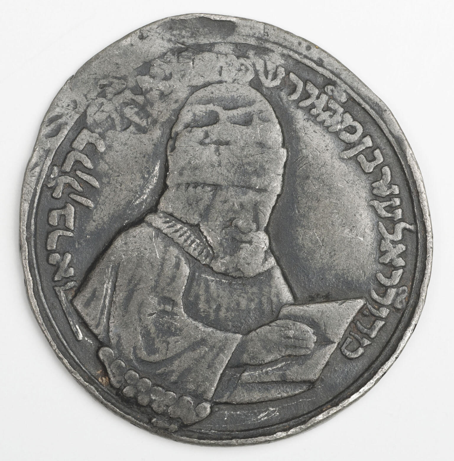 Medal of man with open book.