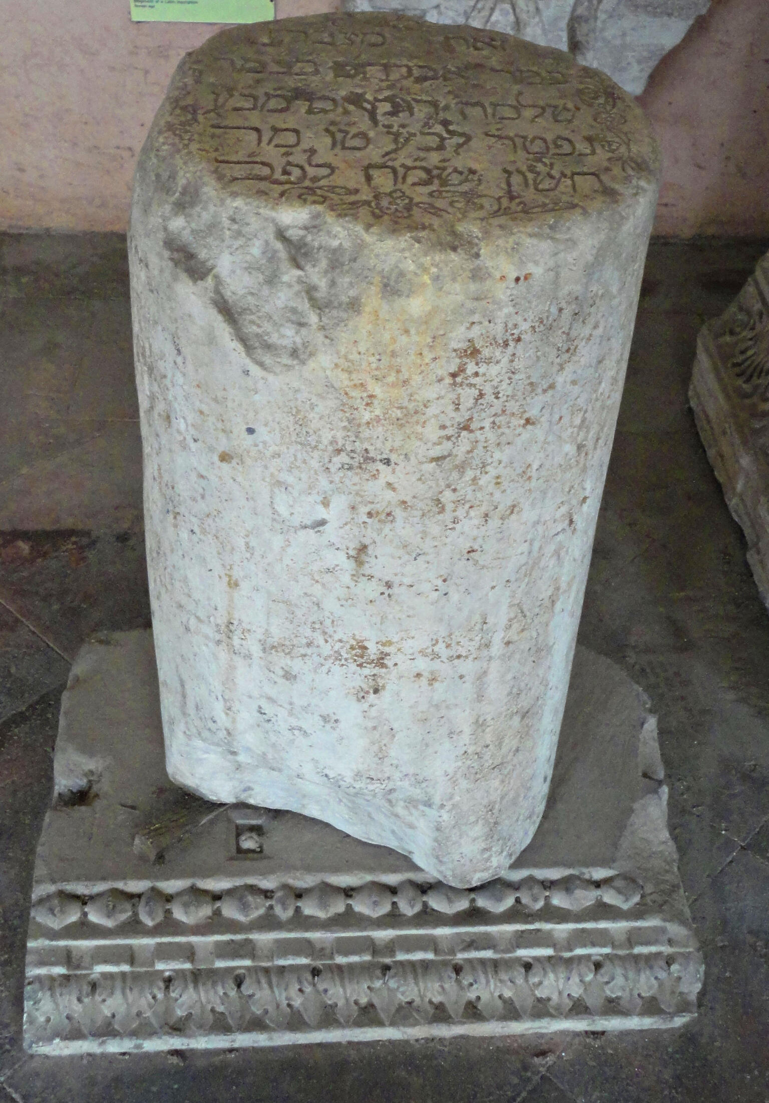 Cylindrical tombstone with Hebrew on top, sitting on decorative base. Cylindrical tombstone with Hebrew on top, sitting on decorative base.