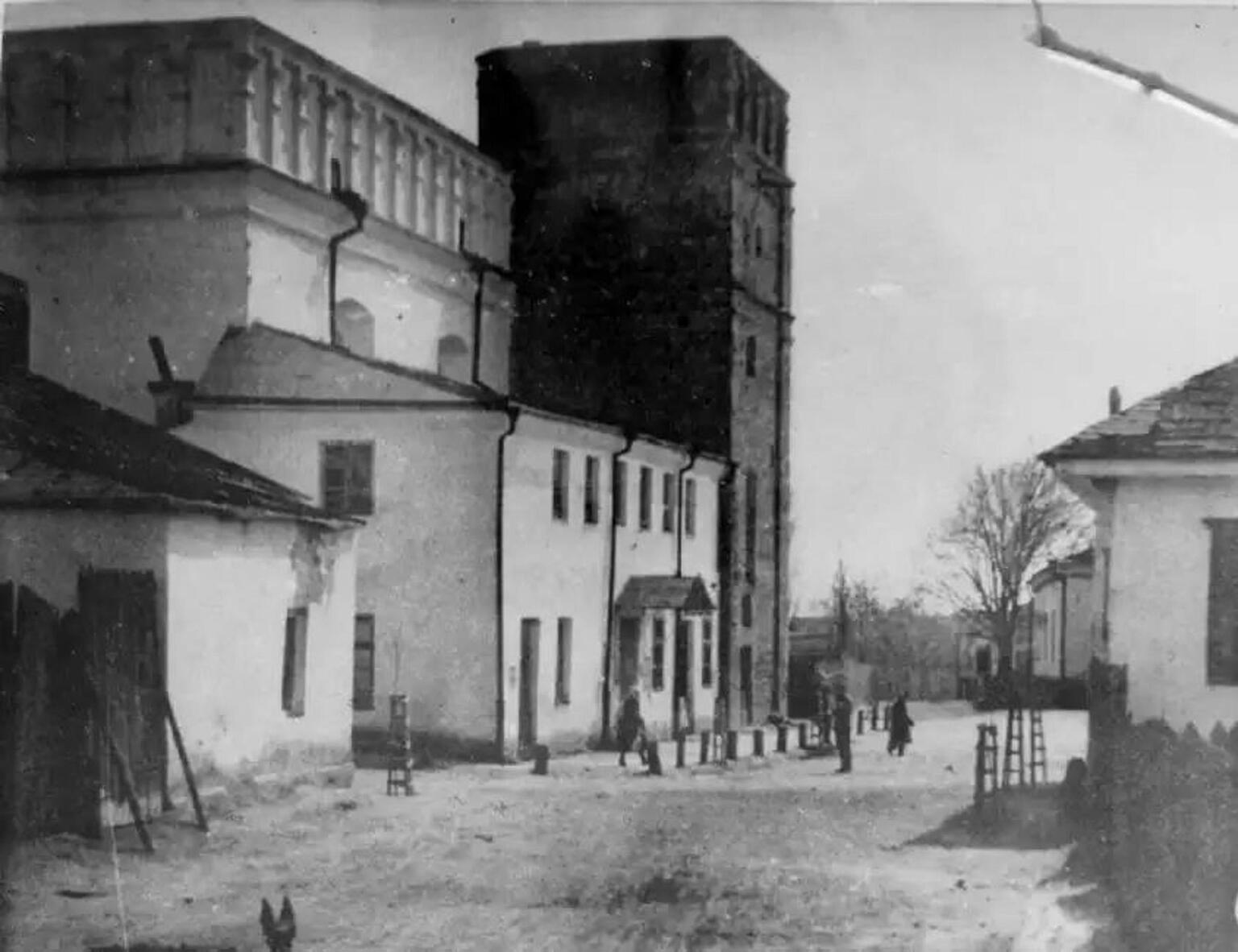 Exterior photograph of street with several buildings on left and one on right. 