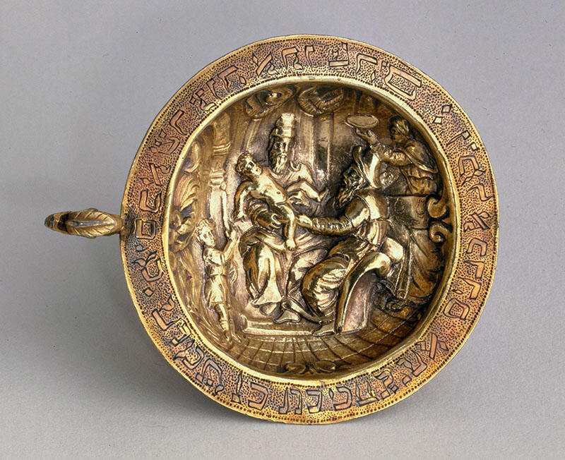 Plate engraved with Hebrew letters around rim and image of man holding child on a chair. Plate engraved with Hebrew letters around rim and image of man holding child on a chair.