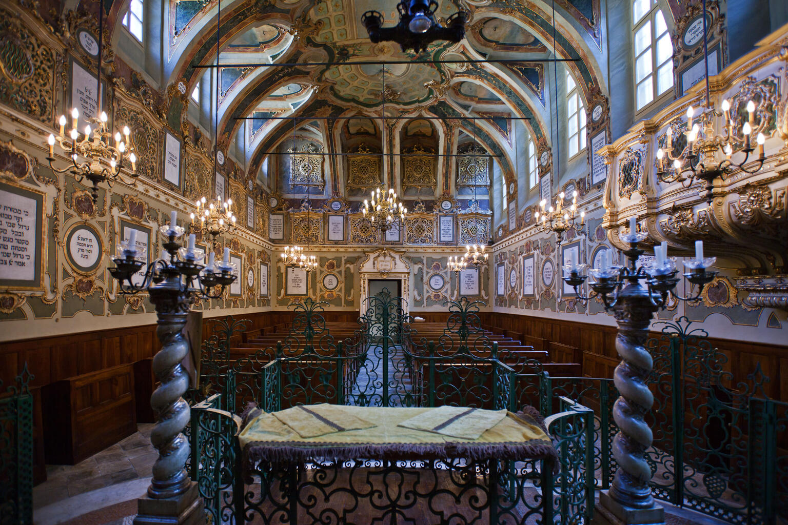 Photograph of room with vaulted ceiling, gilded walls, and pews.