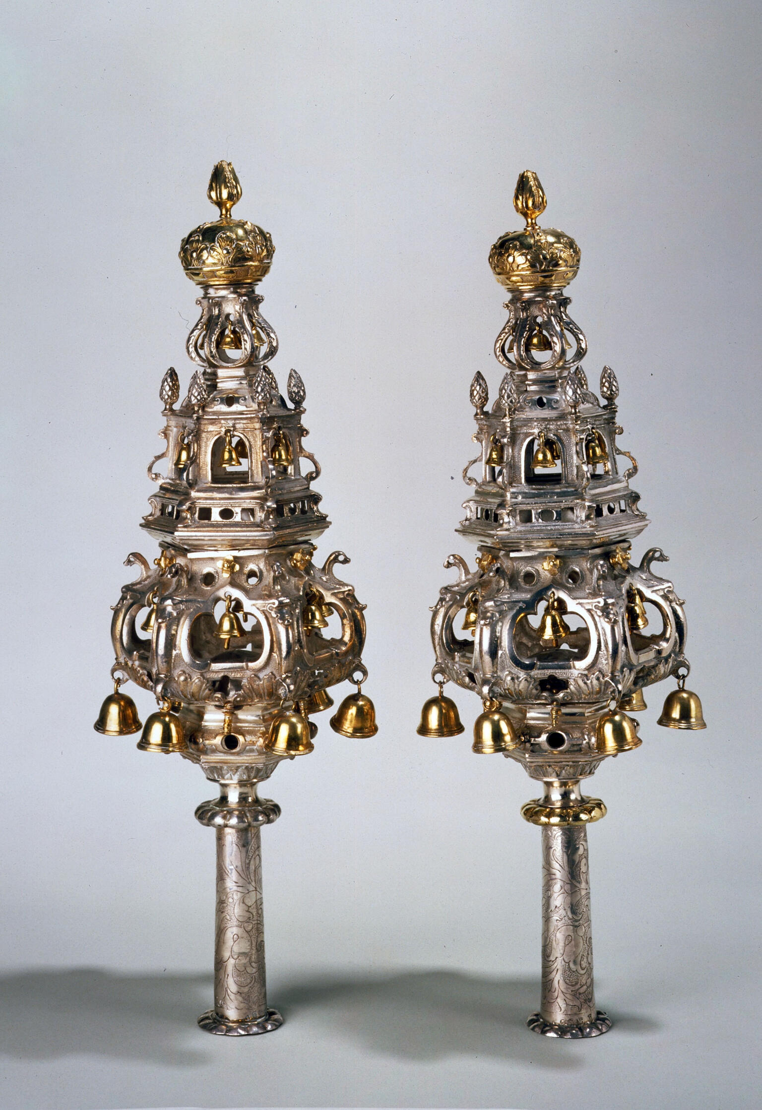 Pair of finials with decorated tiers and bells.