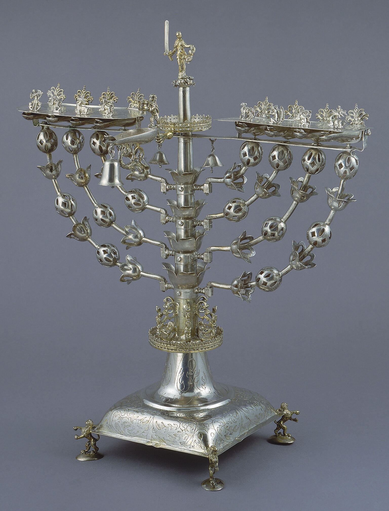 Eight-branched candelabrum with figure on top brandishing sword.