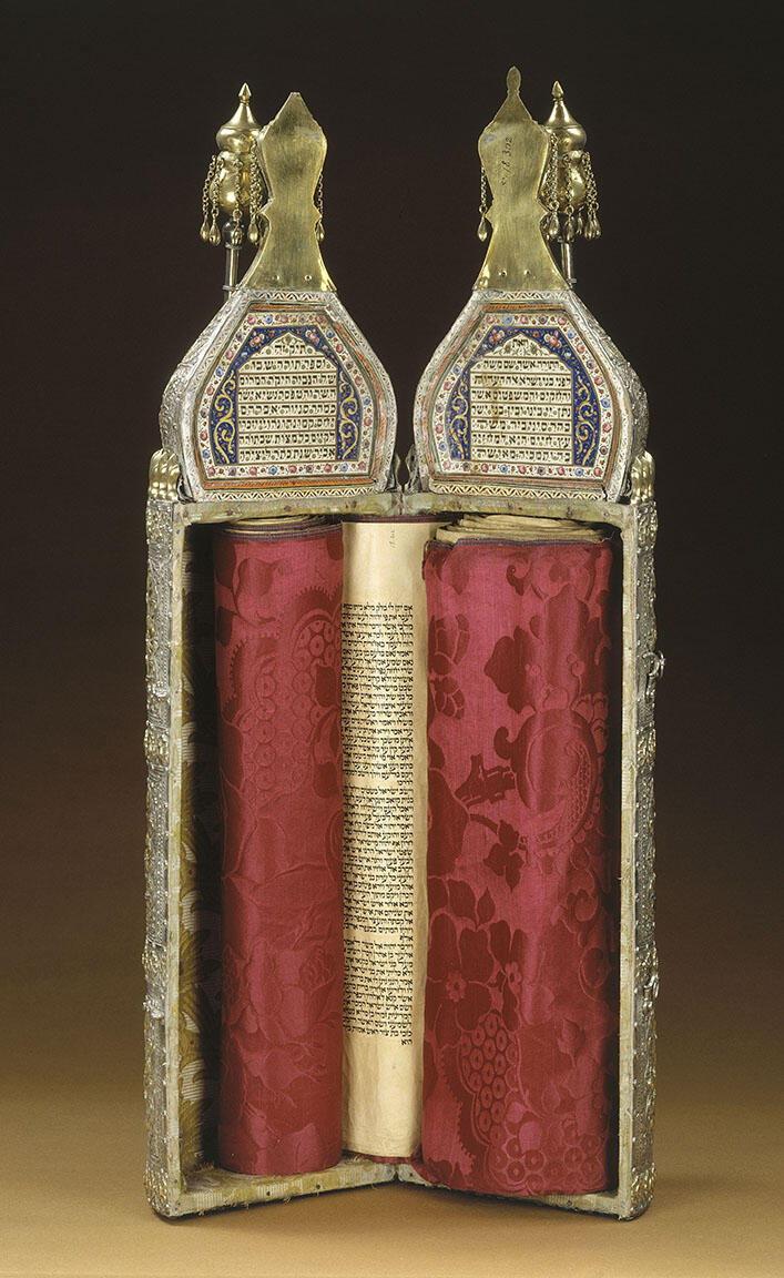 Ornately decorated cylindrical case with Hebrew writing on top and scroll inside; closed cylindrical case with ornate decoration. Ornately decorated cylindrical case with Hebrew writing on top and scroll inside; closed cylindrical case with ornate decoration.