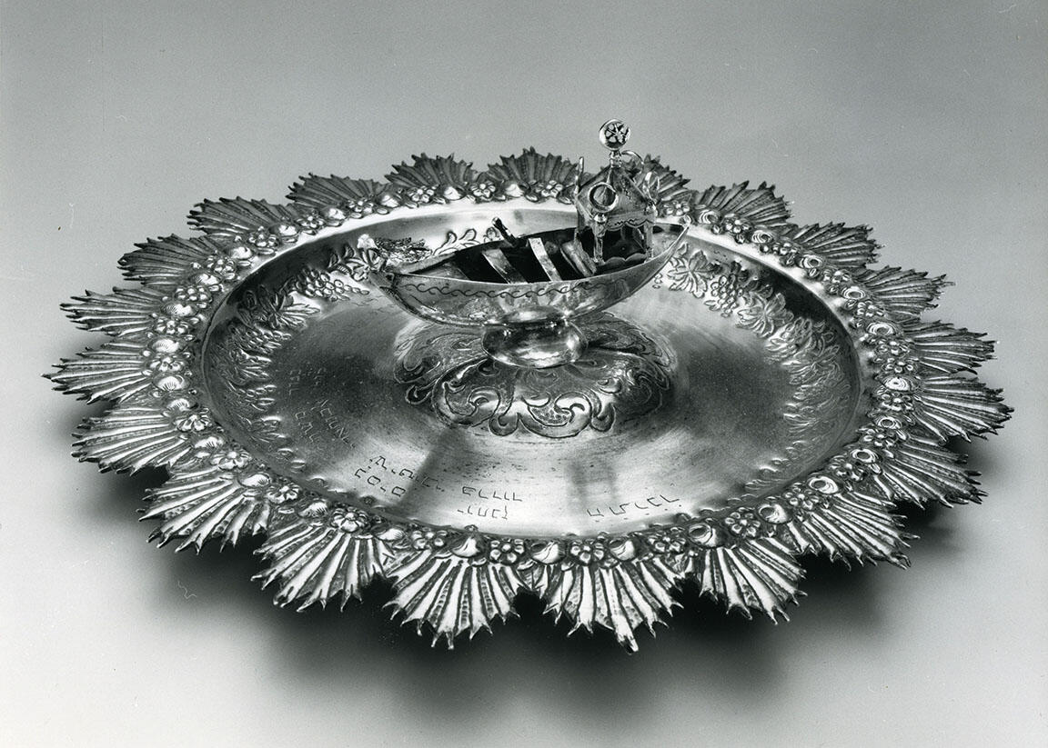 Silver plate featuring a boat in the center. Silver plate featuring a boat in the center.