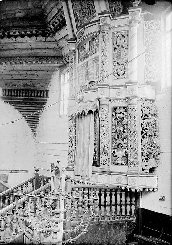 Photograph of interior of building featuring menorah and decorated Torah ark. Photograph of interior of building featuring menorah and decorated Torah ark.