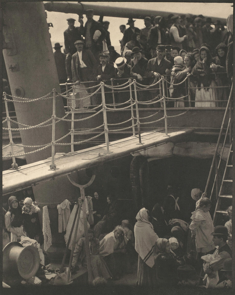 Photograph of a ship deck with two stories filled with people. Photograph of a ship deck with two stories filled with people.