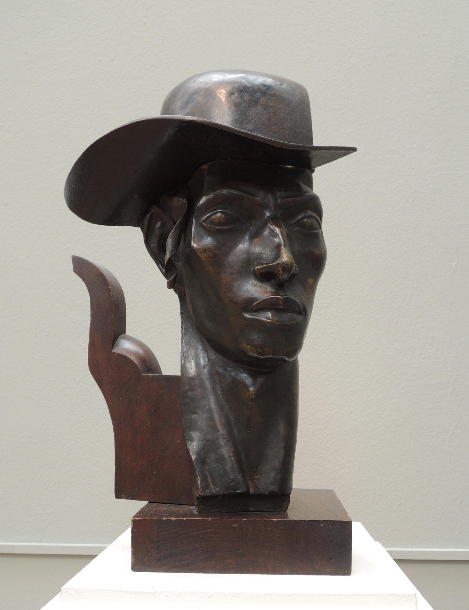 Bust of man wearing a hat.