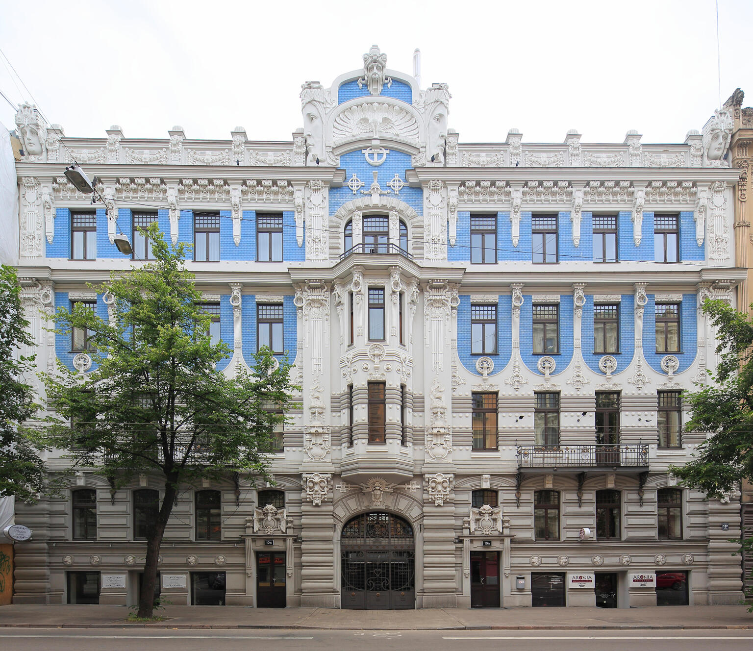 Façade of symmetrical building with horizontal lines and many geometric patterns.