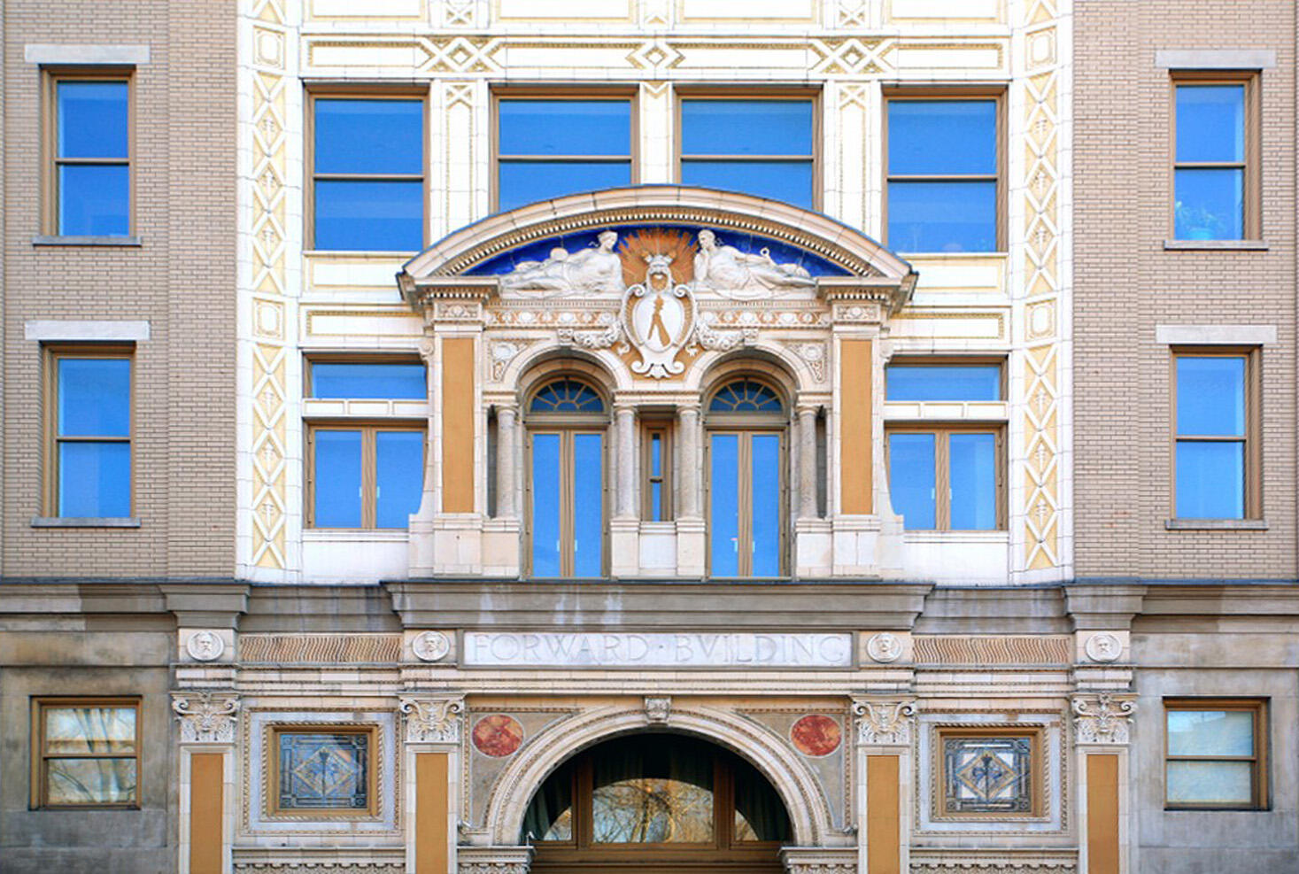 Façade of building with arched entryways and columns with ornate capitals.