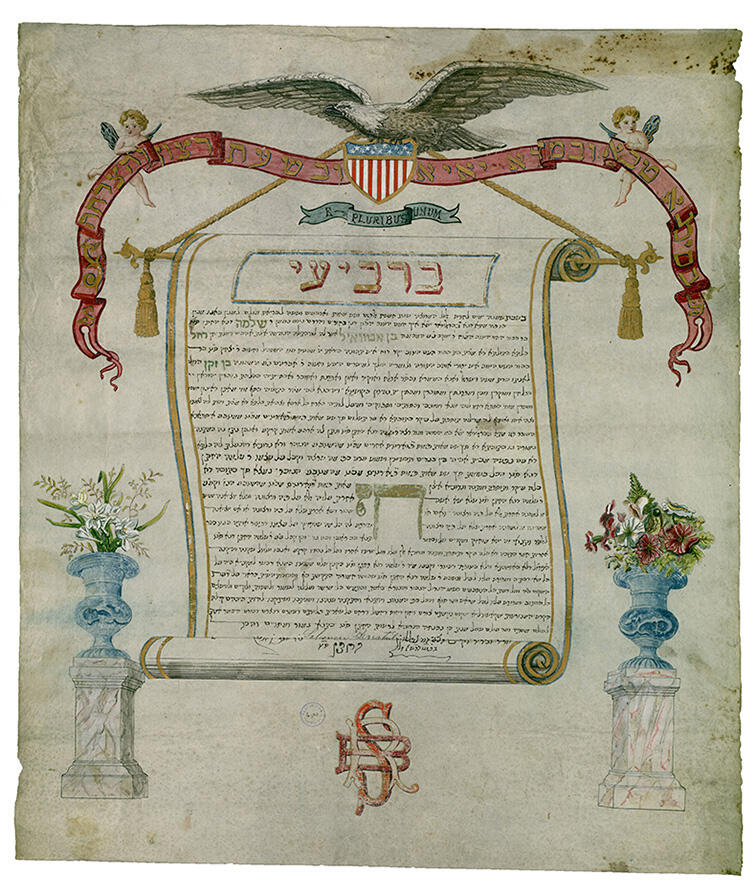 Paper with central Aramaic text surrounded by drawn scroll, eagle holding shield with American flag, two cherubs holding a sign with English words on it, and flowers on columns below text. Paper with central Aramaic text surrounded by drawn scroll, eagle holding shield with American flag, two cherubs holding a sign with English words on it, and flowers on columns below text.