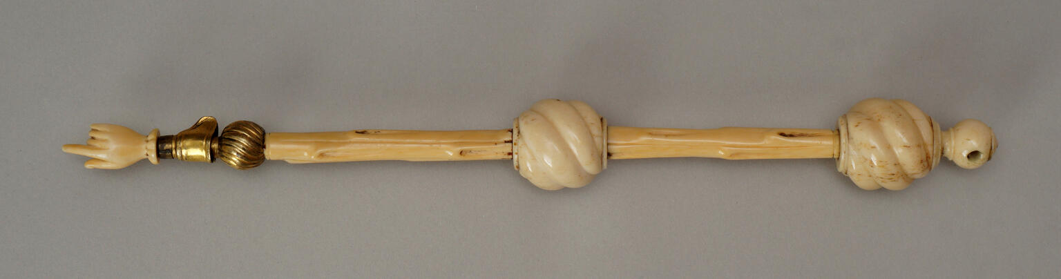 Ivory pointer in shape of hand on one end with three ivory and brass beads. Ivory pointer in shape of hand on one end with three ivory and brass beads.