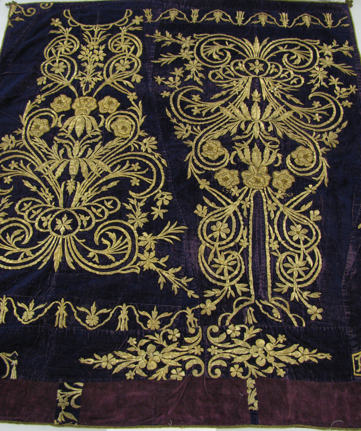 Cloth embroidered with decorative flowers, spirals, and lines. Cloth embroidered with decorative flowers, spirals, and lines.