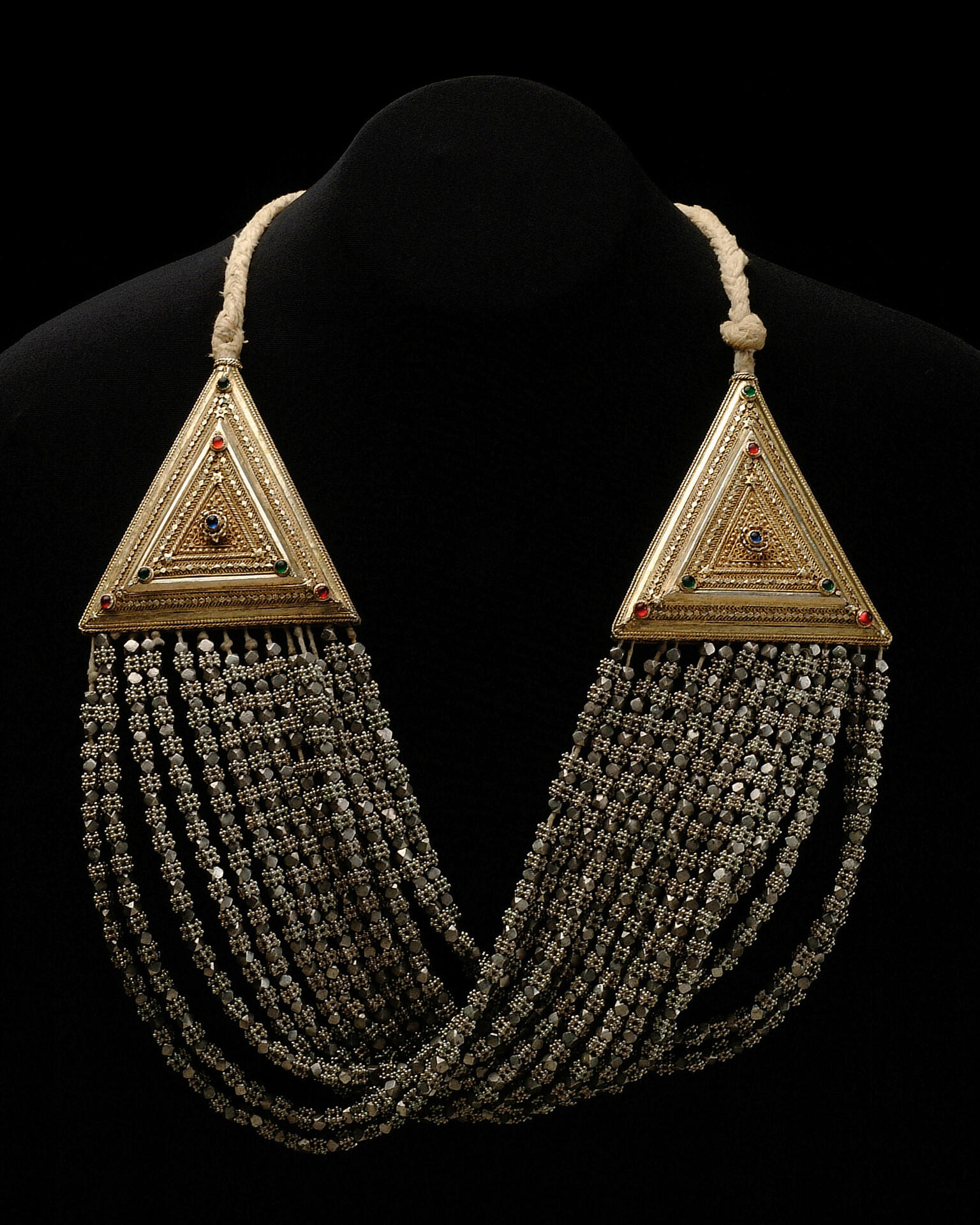 Necklace with triangular settings on either side, with strings of beads running between them.