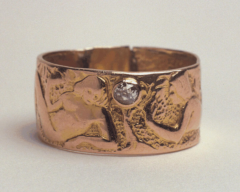 Gold wedding ring stamped with two figures and inlaid with a diamond. Gold wedding ring stamped with two figures and inlaid with a diamond.
