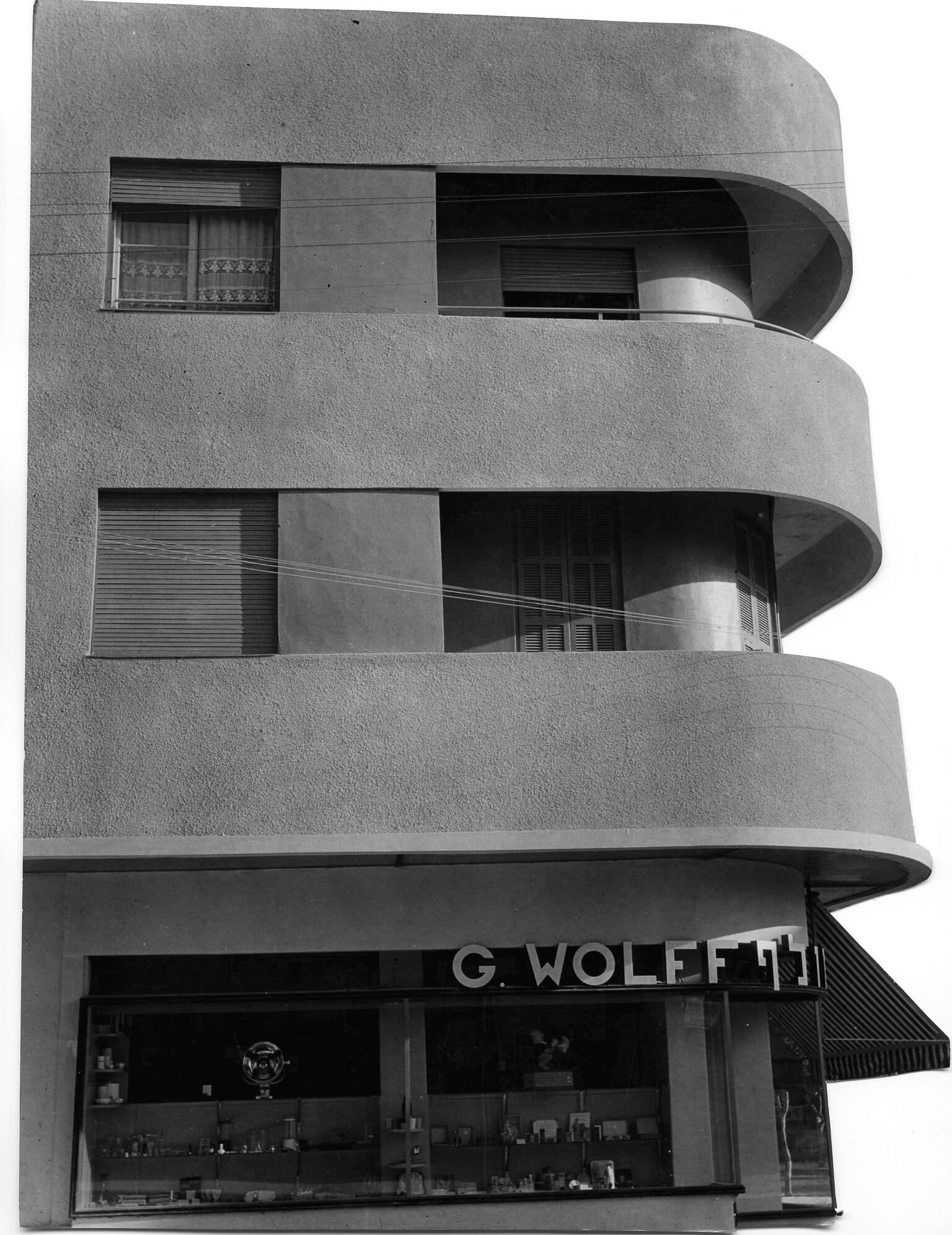 Photograph of side of three-story building exterior featuring sleek, curved balconies. Photograph of side of three-story building exterior featuring sleek, curved balconies.