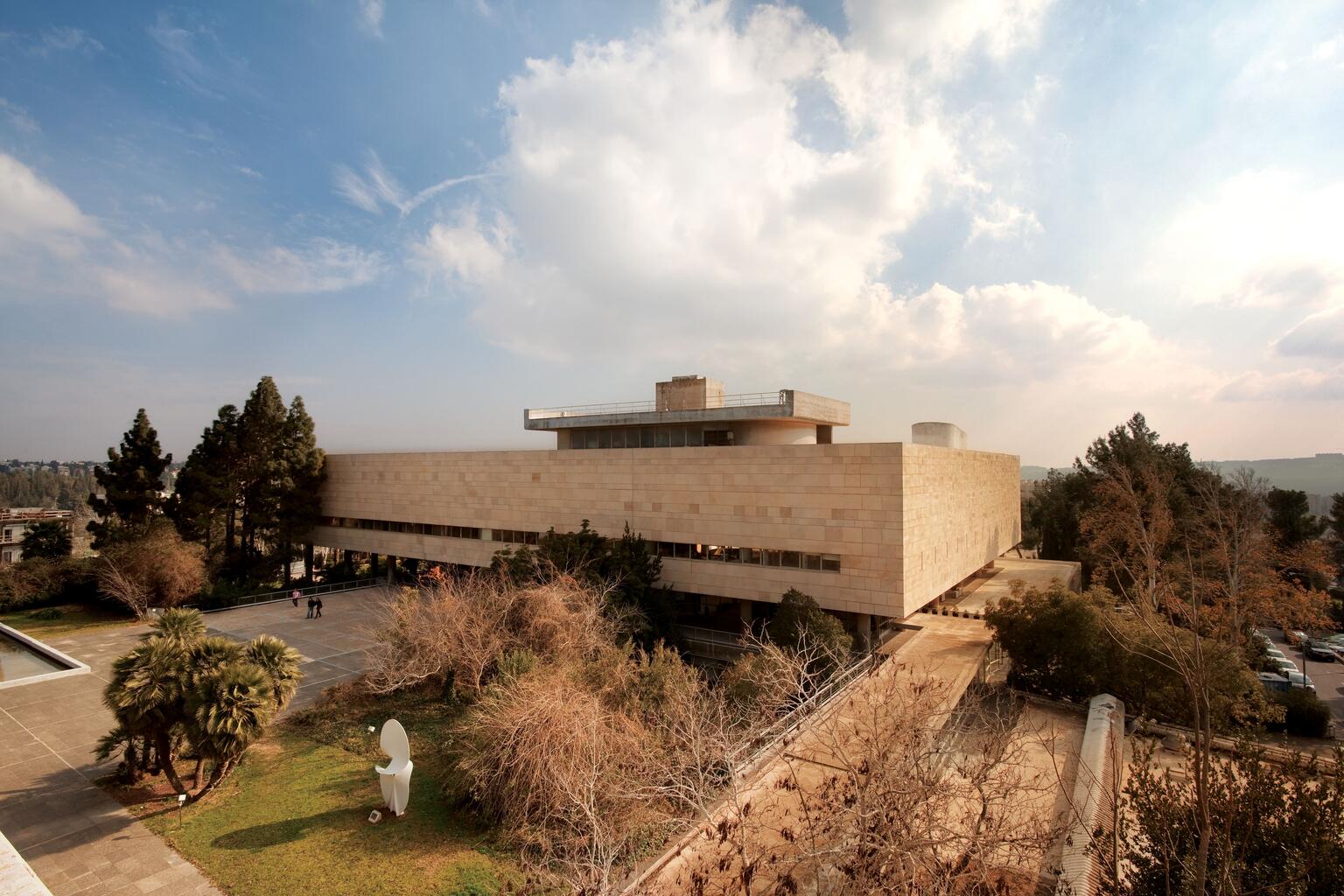 Aerial photograph of a rectangular building with a courtyard and trees.