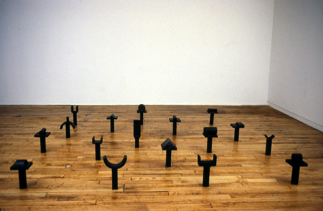 Forged iron installation of glyphs resting on squat pedestals.