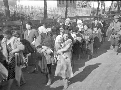 Photo of a line of Jewish women carrying children and belongings.