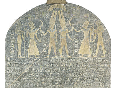 Stone with rounded top with drawing of six figures wielding weapons and Egyptian hieroglyphic writing in rows.