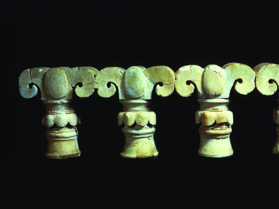 Tops of four columns shaped like palm fronds.
