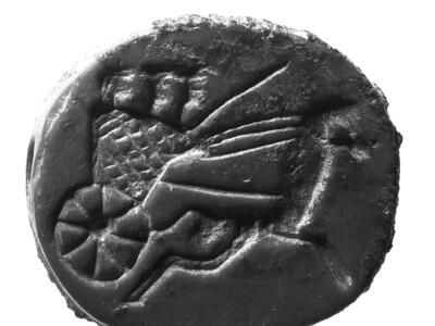 Limestone seal with image of driver and two people in a horse-drawn chariot.