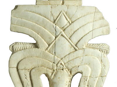 Ivory carving of date palm featuring layers of fronds with small protrusions at top and bottom.