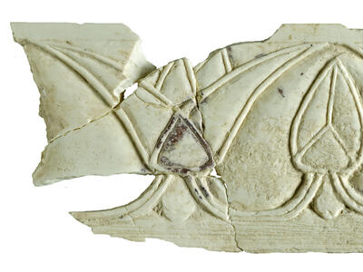 Ivory carving of a horizontal series of lotus flowers with alternating open and closed buds.