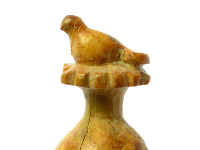 Sculpture of pomegranate with a bird on top.