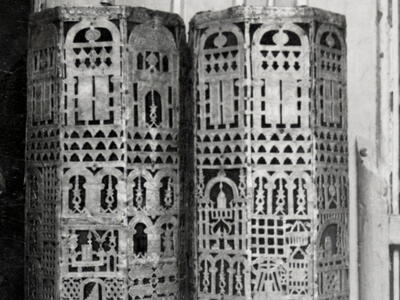 Cylindrical cases carved with geometric designs.