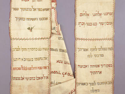 Rectangular cloth arranged in two columns embroidered with Hebrew text and small Star of David on right side. 