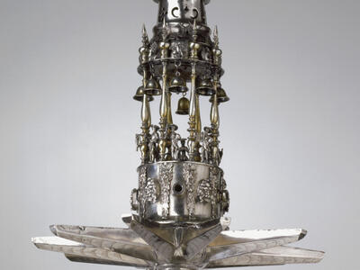 Silver multi-tiered hanging lamp with sculpture of lion on top. 