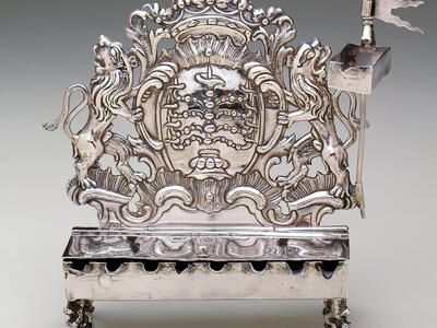 Silver oil lamp with lions on each side and crown on top. 